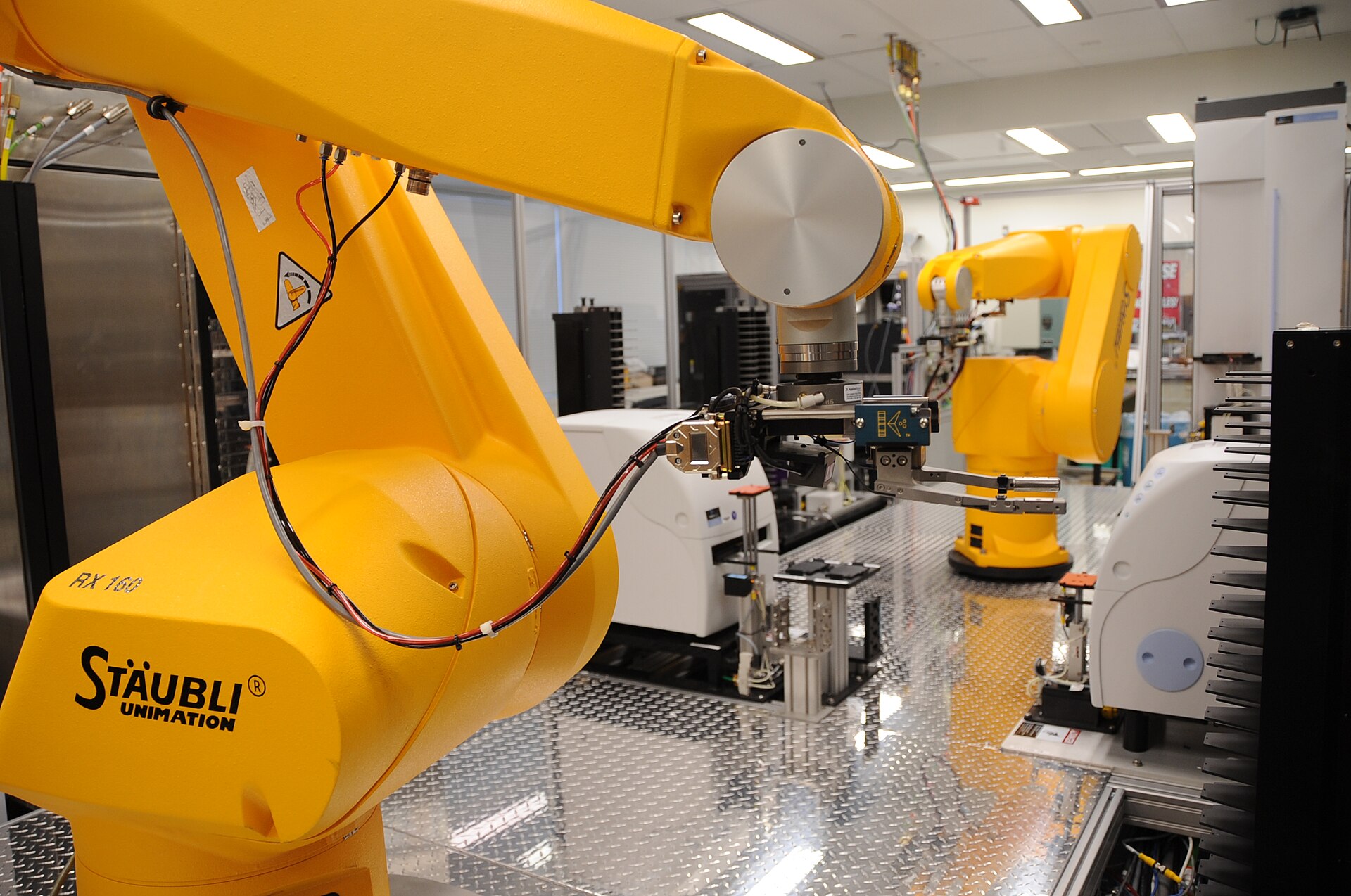 Yellow robotic arms of a chemical genomics automation line