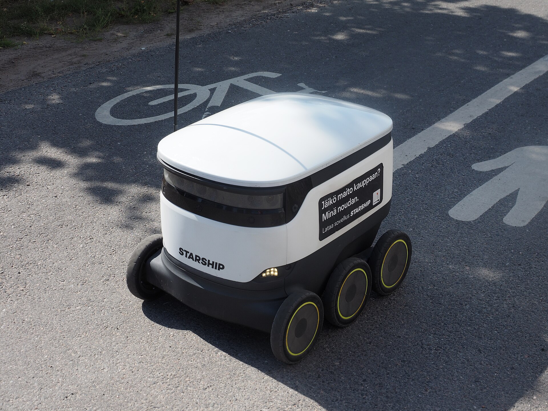 A six-wheeled Starship delivery robot on a bicycle lane
